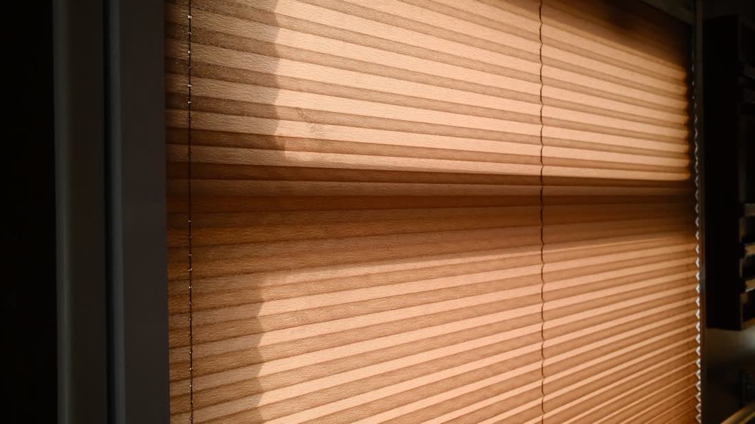 Cortina plisada de madera filtrando la luz